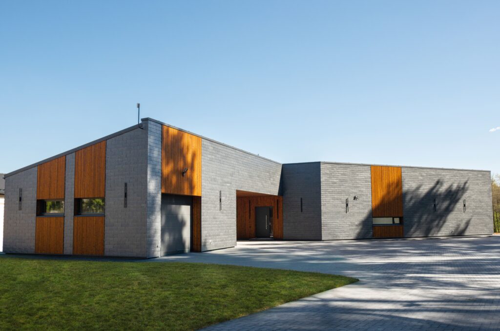 Modernus namas su skalūno akmens fasadu ir degintos medienos akcentu - šiuolaikinė architektūra